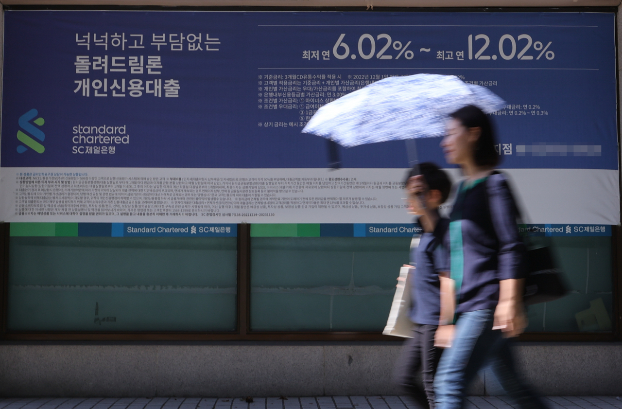 서울 한 시중은행의 대출 안내문 앞을 시민이 지나가고 있다.[연합]