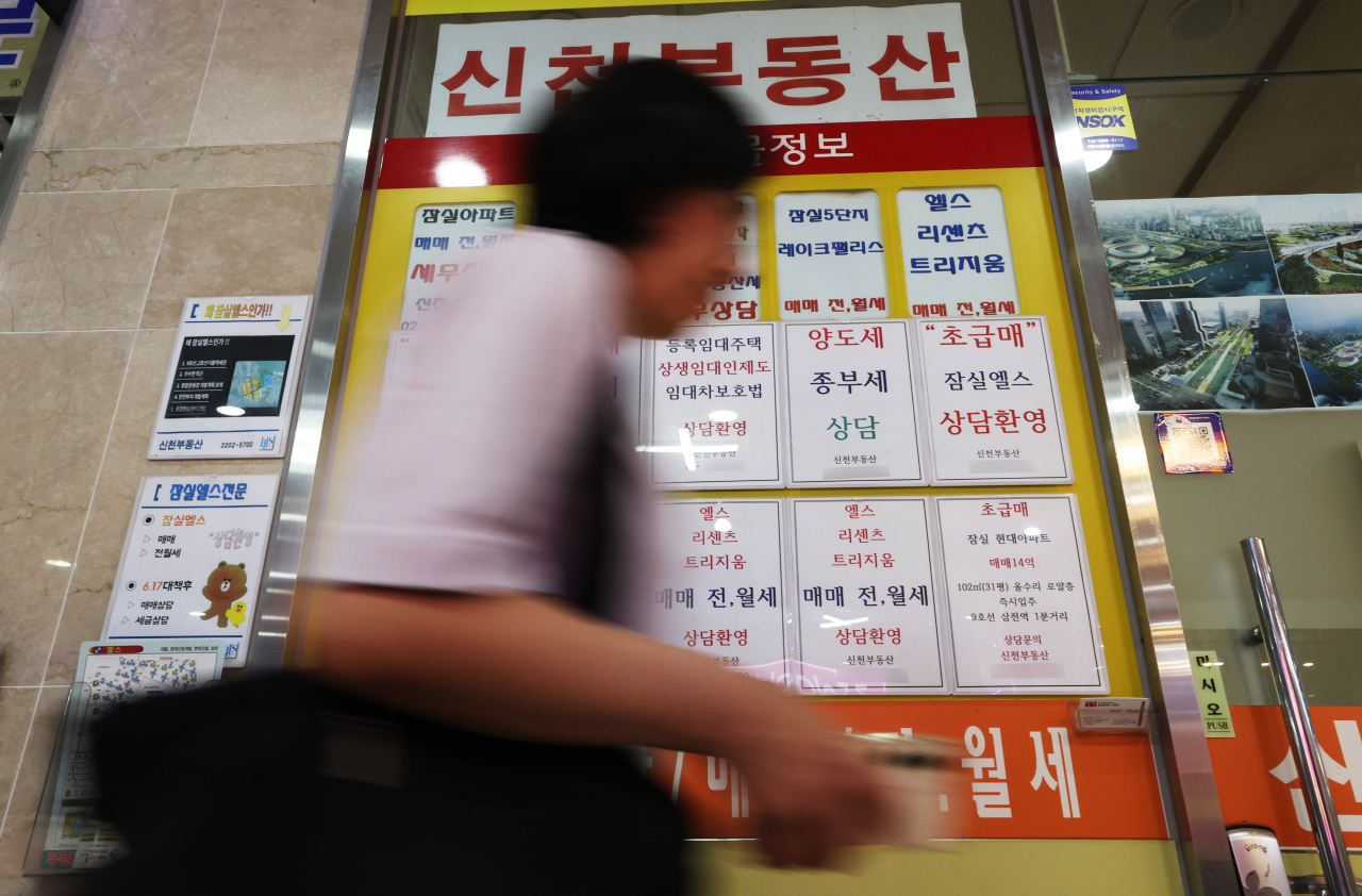 서울 한 부동산중개사무소 앞을 시민이 지나가고 있다.[연합]