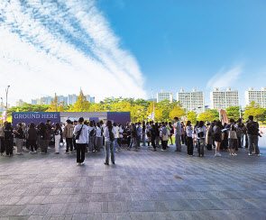 5일 오전 부산 해운대구 영화의전당 두레라움 광장에 마련된 굿즈 매장 앞에 영화팬들이 길게 줄 선 모습. [이현정 기자]