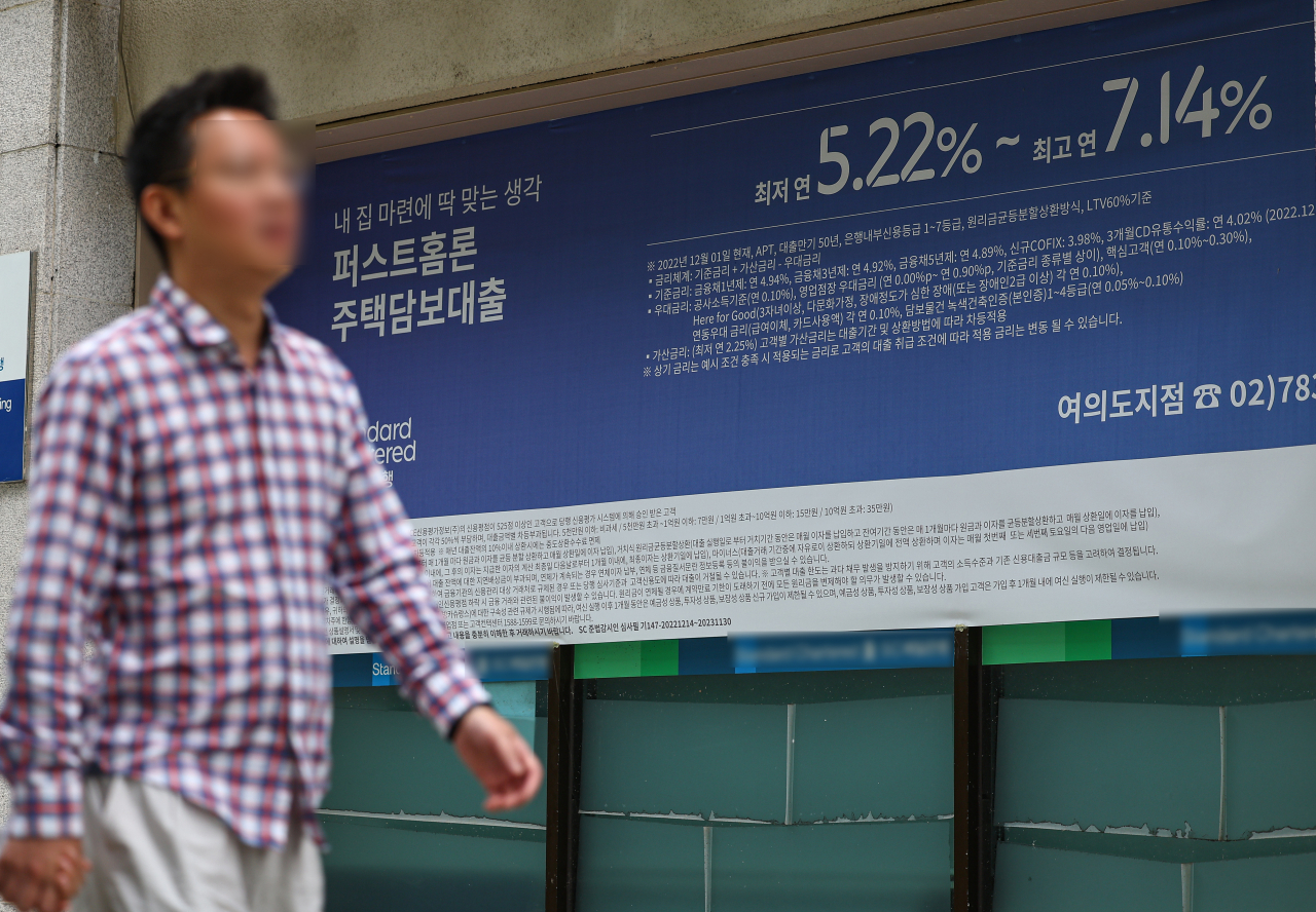 서울 한 시중은행의 대출 안내문 앞을 시민이 지나가고 있다.[연합]