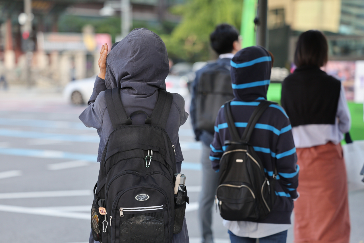 지난 쌀쌀한 가을 날씨를 보인 5일 오전 서울 종로구 광화문네거리에서 외투와 긴팔 옷을 입은 시민들이 횡단보도 신호를 기다리고 있다. [연합]