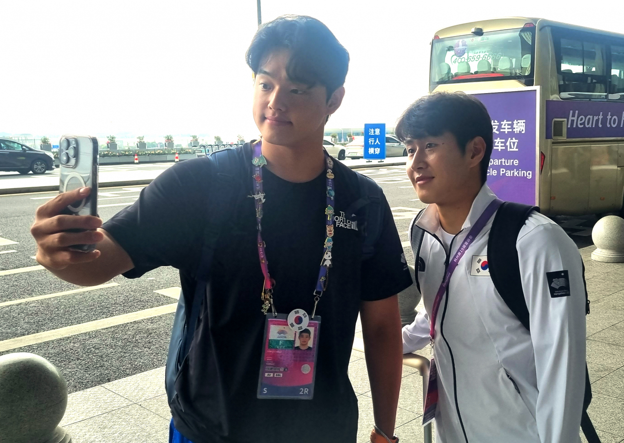 축구대표팀 이강인(오른쪽)과, 야구대표팀 문동주가 8일 중국 항저우 샤오산 국제공항 출국장에서 함께 사진촬영을 하고 있다. [연합]