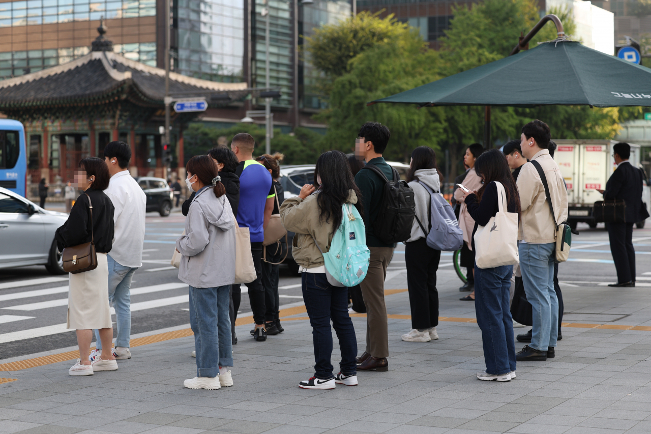 쌀쌀한 가을 날씨를 보인 10일 오전 서울 종로구 광화문네거리에서 외투를 입은 시민들이 횡단보도 신호를 기다리고 있다. [연합]
