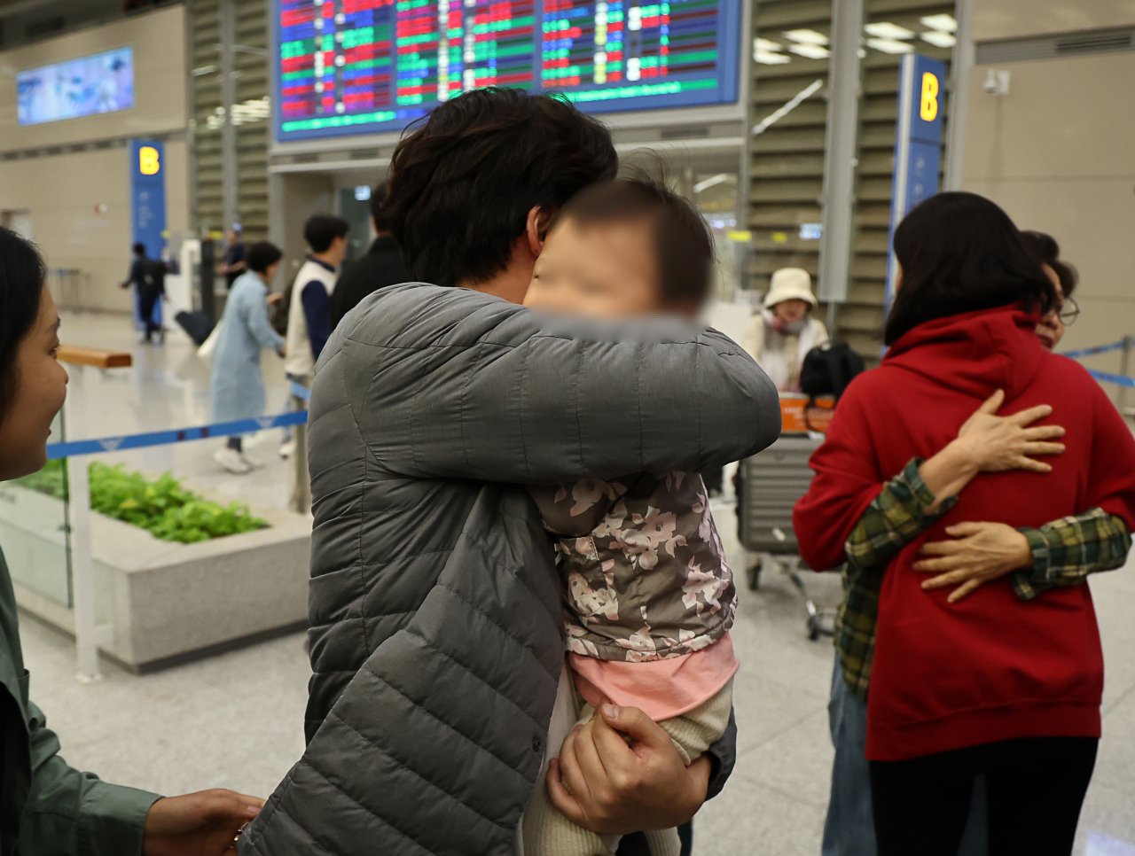 11일 오전 인천국제공항 2터미널 입국장에서 한 아버지가 이스라엘 텔아비브 공항에서 귀국하는 가족을 반기고 있다. [연합]