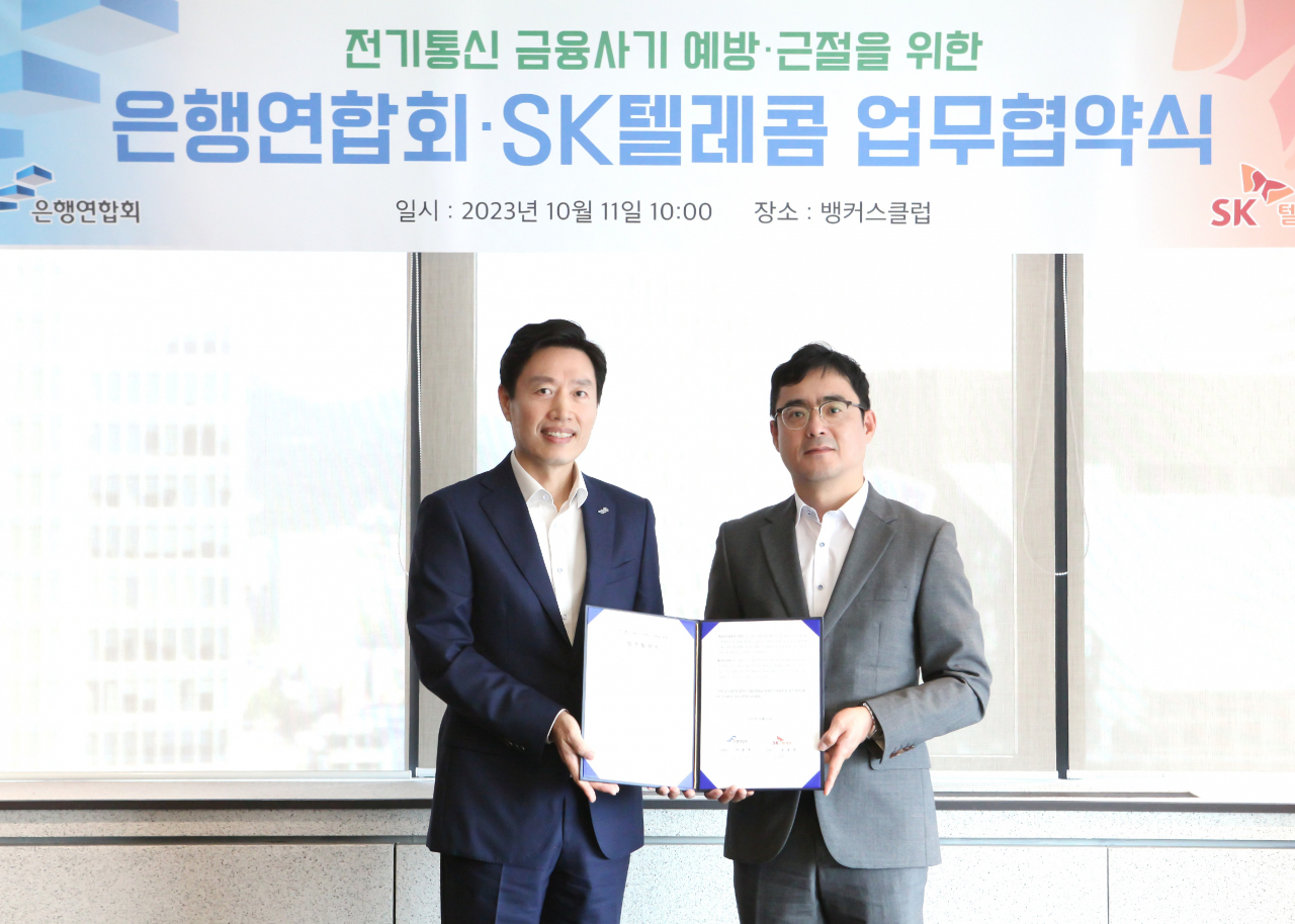 11일 서울 중구 은행회관에서 열린 협약식에서 지순구 은행연합회 본부장과 손영규 SK텔레콤 부사장이 기념촬영을 하고 있다.[은행연합회 제공]