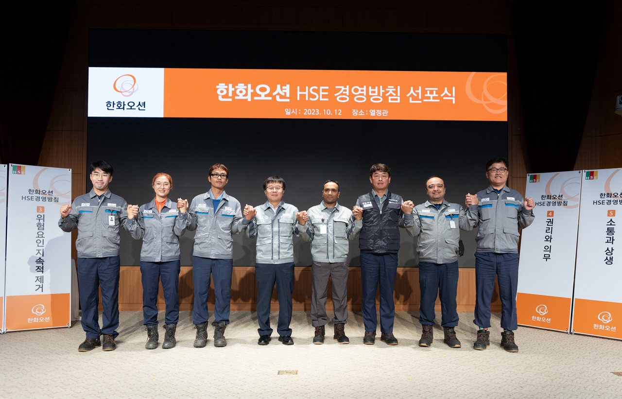 12일 거제사업장에서 진행된 '한화오션 HSE 경영방침 선포식'에서 권혁웅(왼쪽 네번째) 대표이사 부회장, 정상헌(왼쪽 여섯번째) 노조 지회장, 외국인 근로자들을 포함한 직원들이 안전 최우선 실천을 다짐하고 있다. [한화오션 제공]