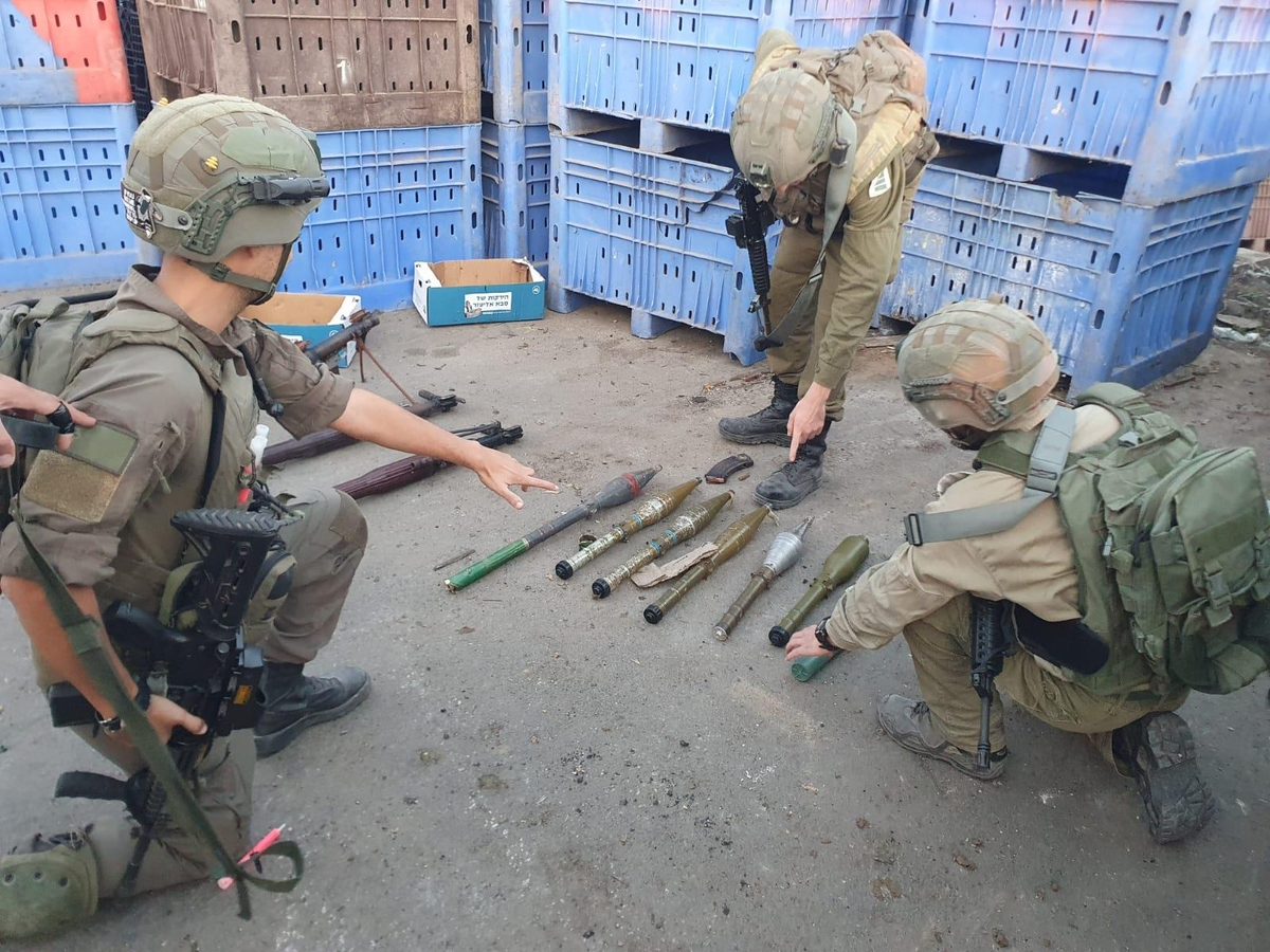 이스라엘군(IDF)이 하마스로부터 압수한 무기들을 지난 11일 홈페이지에 공개한 가운데, 왼쪽 장병이 손가락으로 가리키는 무기가 북한제 F-7 로켓추진유탄(RPG) 발사기로 추정된다. [IDF 홈페이지 캡처]