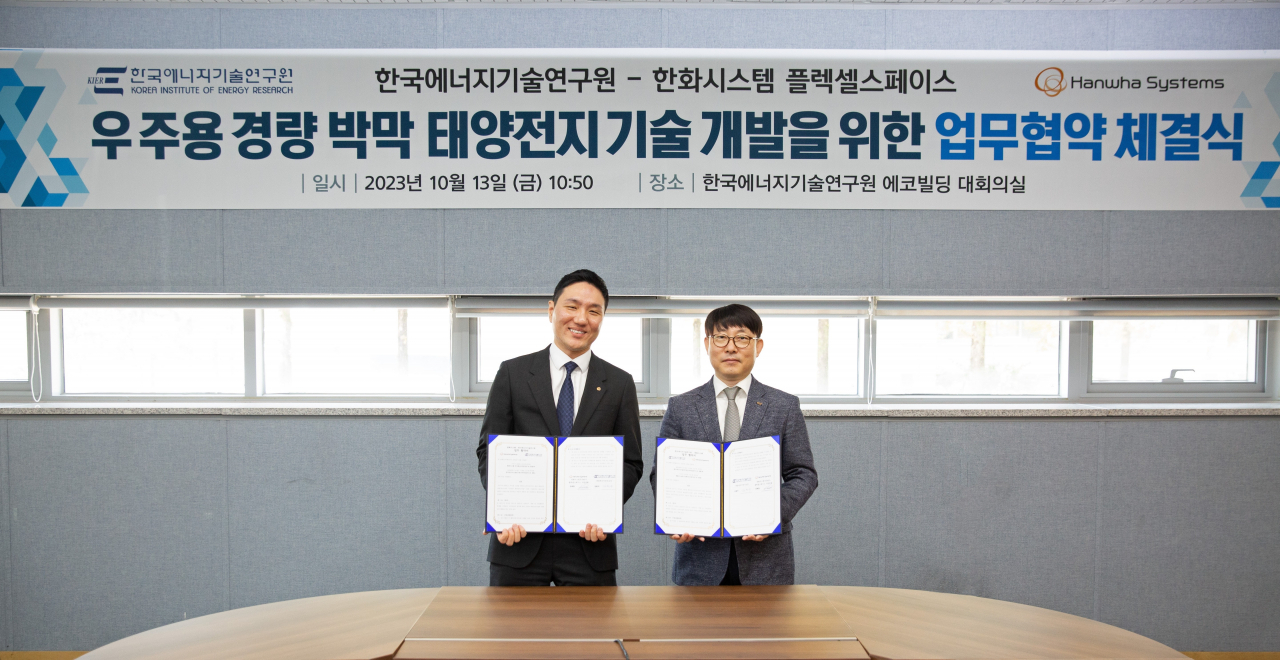 안태훈(왼쪽) 한화시스템 전문연구원 겸 플렉셀 스페이스 대표 김현구 한국에너지기술연구원 재생에너지 연구소장이 13일 우주용 태양전지 기술협력 업무협약(MOU)을 체결한 뒤 기념촬영을 하고 있다. [한화시스템 제공]