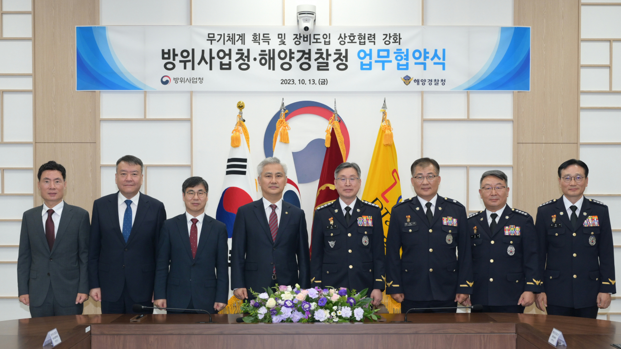 방위사업청 대전청사에서 열린 방위사업청-해양경찰청 업무 협약식 후 엄동환 방사청장(중앙 좌)과 김종욱 해경청장(중앙 우)을 비롯한 주요직위자들이 단체사진을 촬영하고 있다.[방사청 제공]