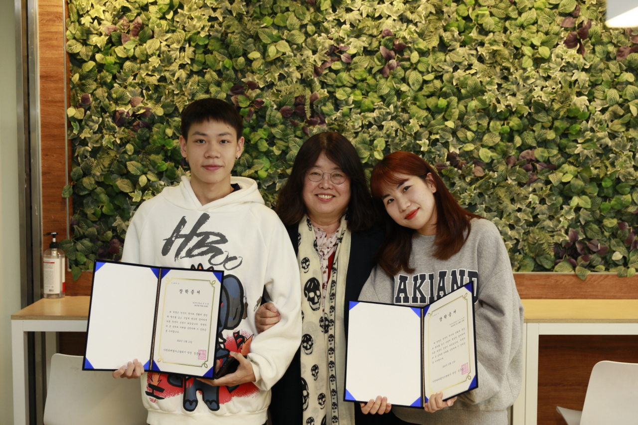 가천대 이현숙 강사가 13일 대학 비전타워에서 열린 장학증서 수여식에서 장학증서를 투안쾅, 티한띠엔 학생에게 전달하고 기념사진을 촬영하고 있다.