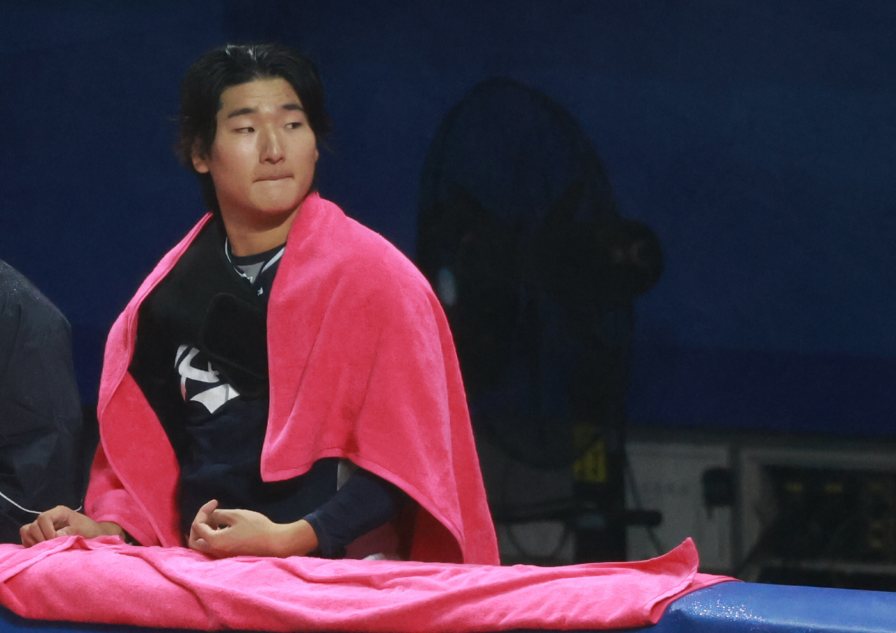 곽빈이 항저우 아시안게임 경기 중 더그아웃에서 수건을 어깨에 두른 채 경기를 살피고 있다. [연합]