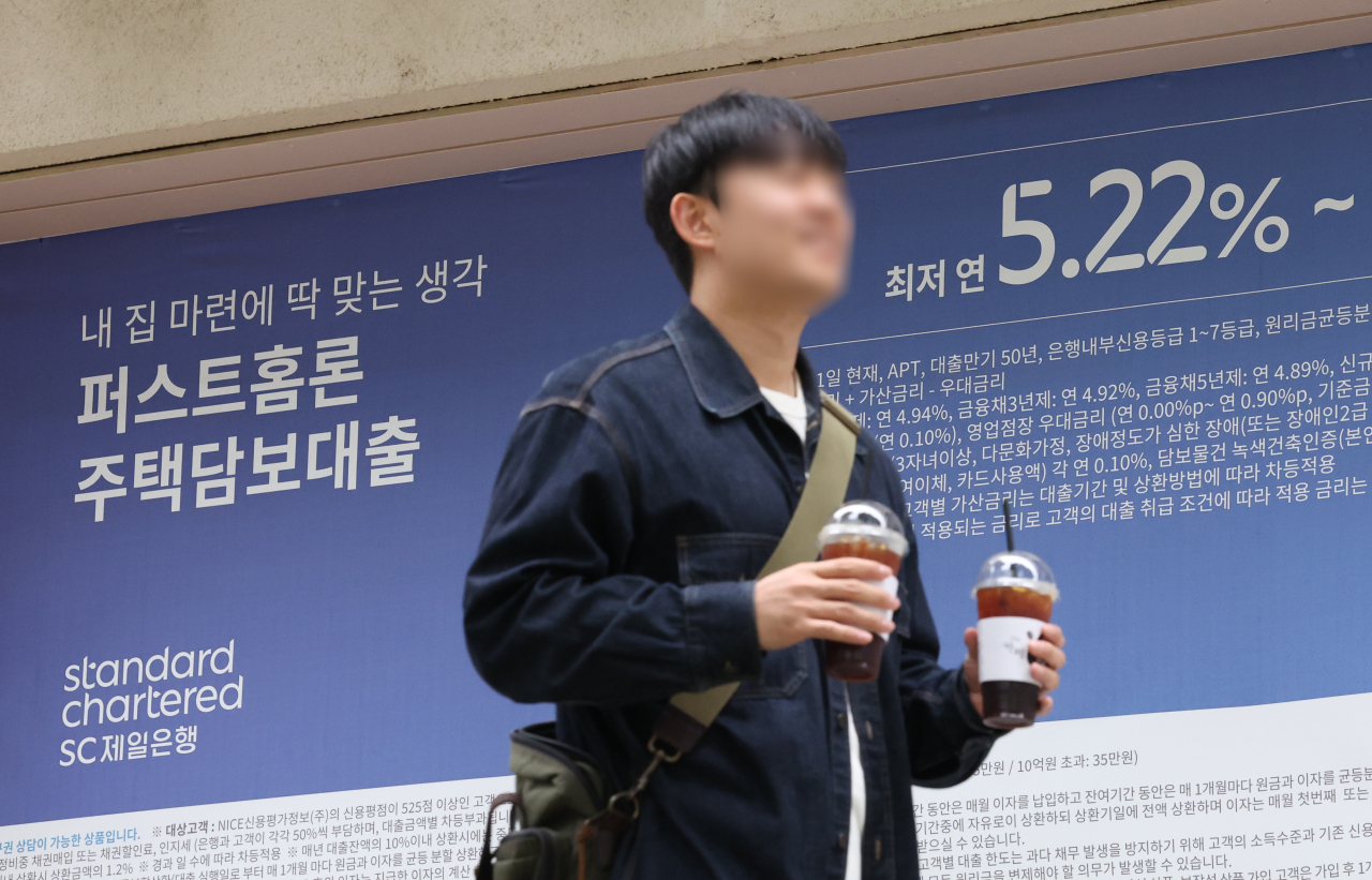 서울 한 시중은행의 대출 안내문 앞을 시민이 지나가고 있다.[연합]
