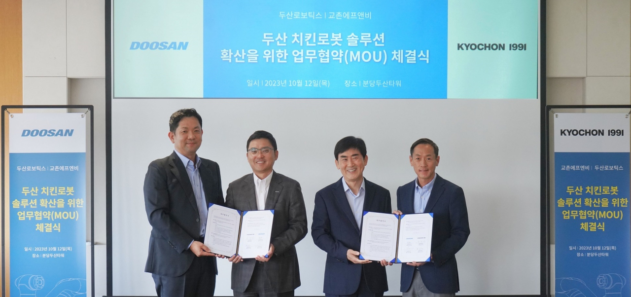 12일 경기 성남시 분당두산타워에서 윤진호(왼쪽부터) 교촌에프앤비 대표이사·류정훈 두산로보틱스 대표·송종화 교촌에프앤비 부회장·박인원 두산로보틱스 대표가 기념촬영을 하고 있다.
