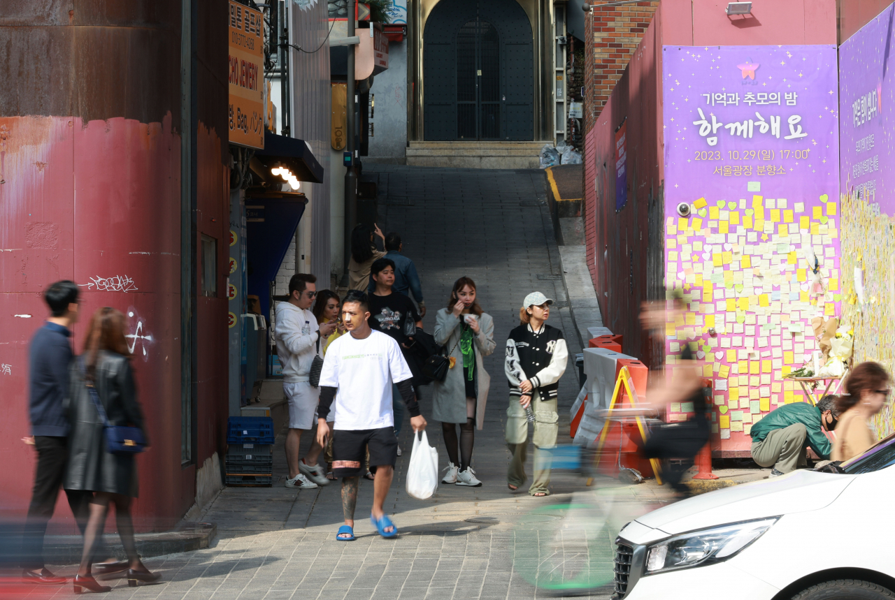 Pedestrians walk through "The Path of Memory and Safety," which has been installed along the main site of last year's Itaewon crowd crush, Sunday. (Yonhap)