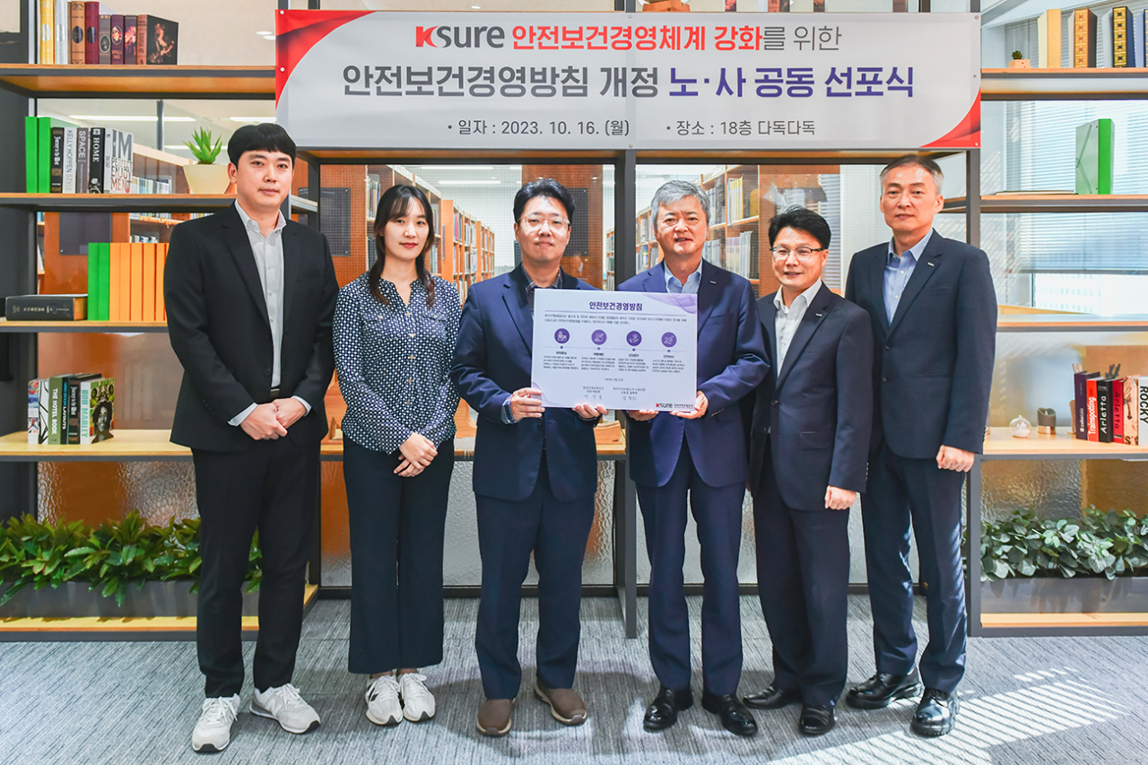 이인호(오른쪽 세번째) 한국무역보험공사 사장과 김덕진(오른쪽 네번째) 무역보험공사 노동조합위원장이 16일 서울 종로구 본사에서 ‘안전보건경영방침 개정’을 노·사 공동으로 선언하고 관계자들과 기념촬영을 하고 있다.［한국무역보험공사 제공］