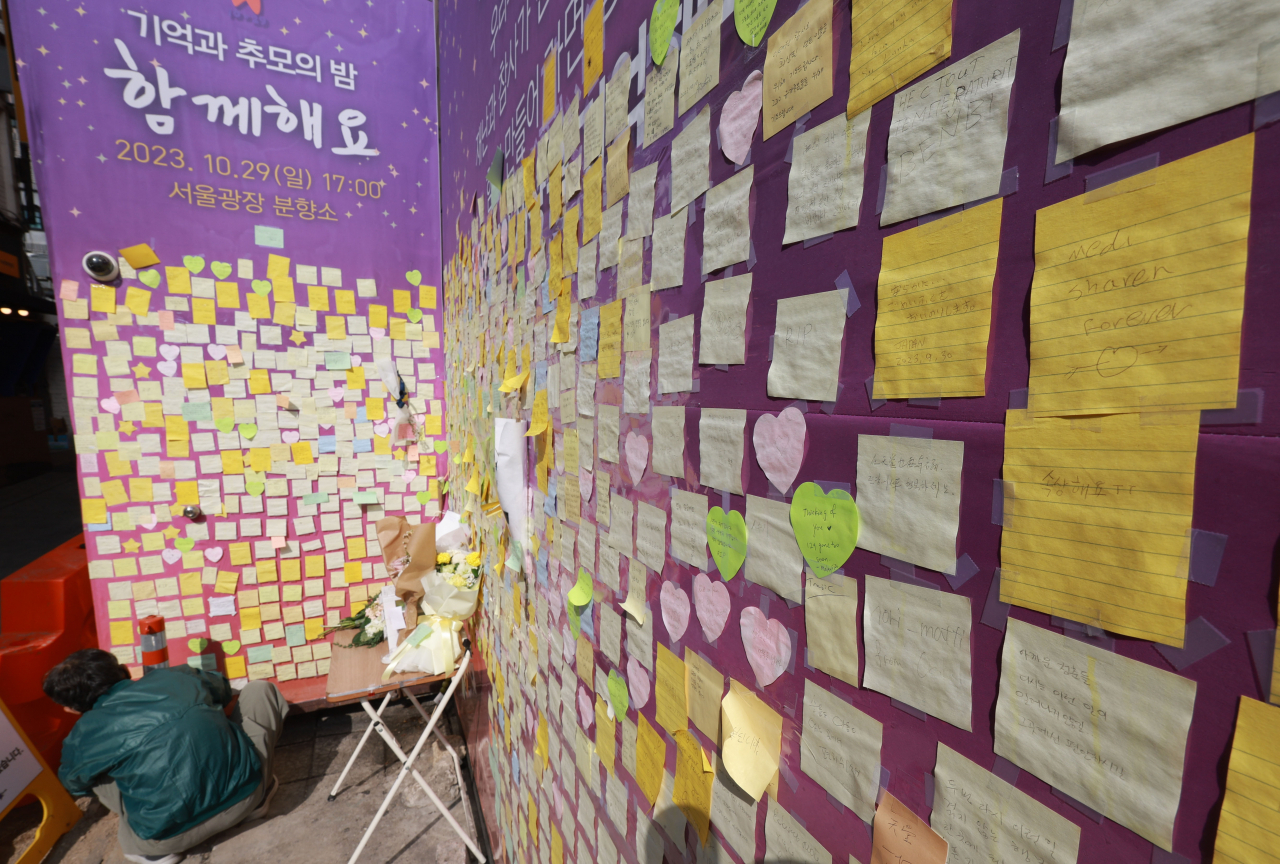 이태원 참사 1주기를 2주 앞둔 15일 서울 용산 이태원의 참사 골목에 설치된 '10.29 이태원 참사 기억의 길'에서 한 시민이 추모메세지를 붙이고 있다. [연합]
