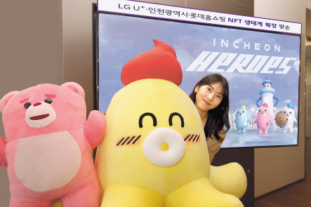 LG유플러스 모델이 인천시와 롯데홈쇼핑 NFT(대체불가토큰)에 활용된 캐릭터와 함께 기념촬영을 하고 있다. [LG유플러스 제공]