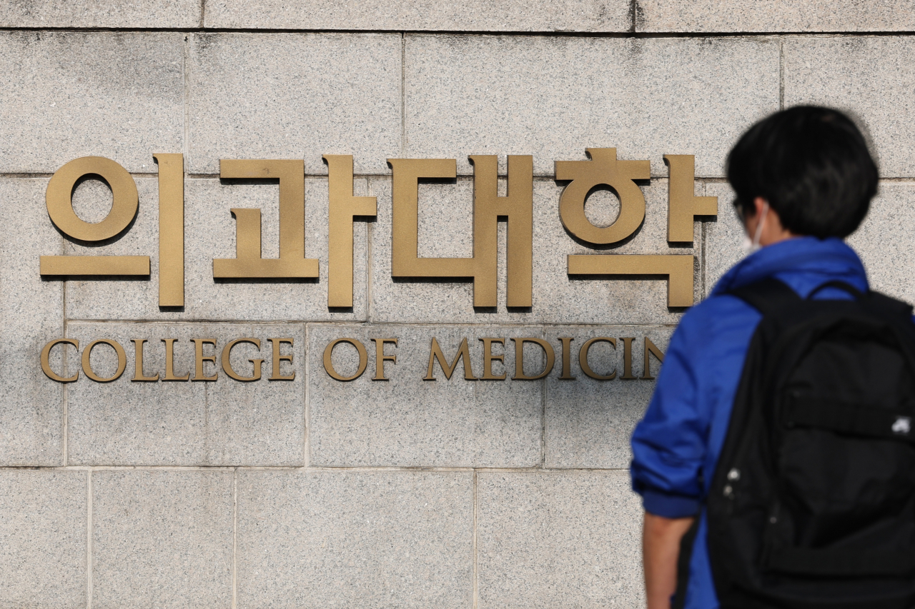 한 의과대학 건물의 표지 앞에 한 학생이 서 있다. [연합]