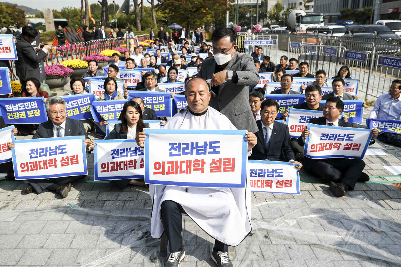 18일 오후 서울 용산 대통령실 앞에서 열린 전라남도 의과대학 신설 촉구대회에서 더불어민주당 김원이 의원이 삭발을 하고 있다.[연합]