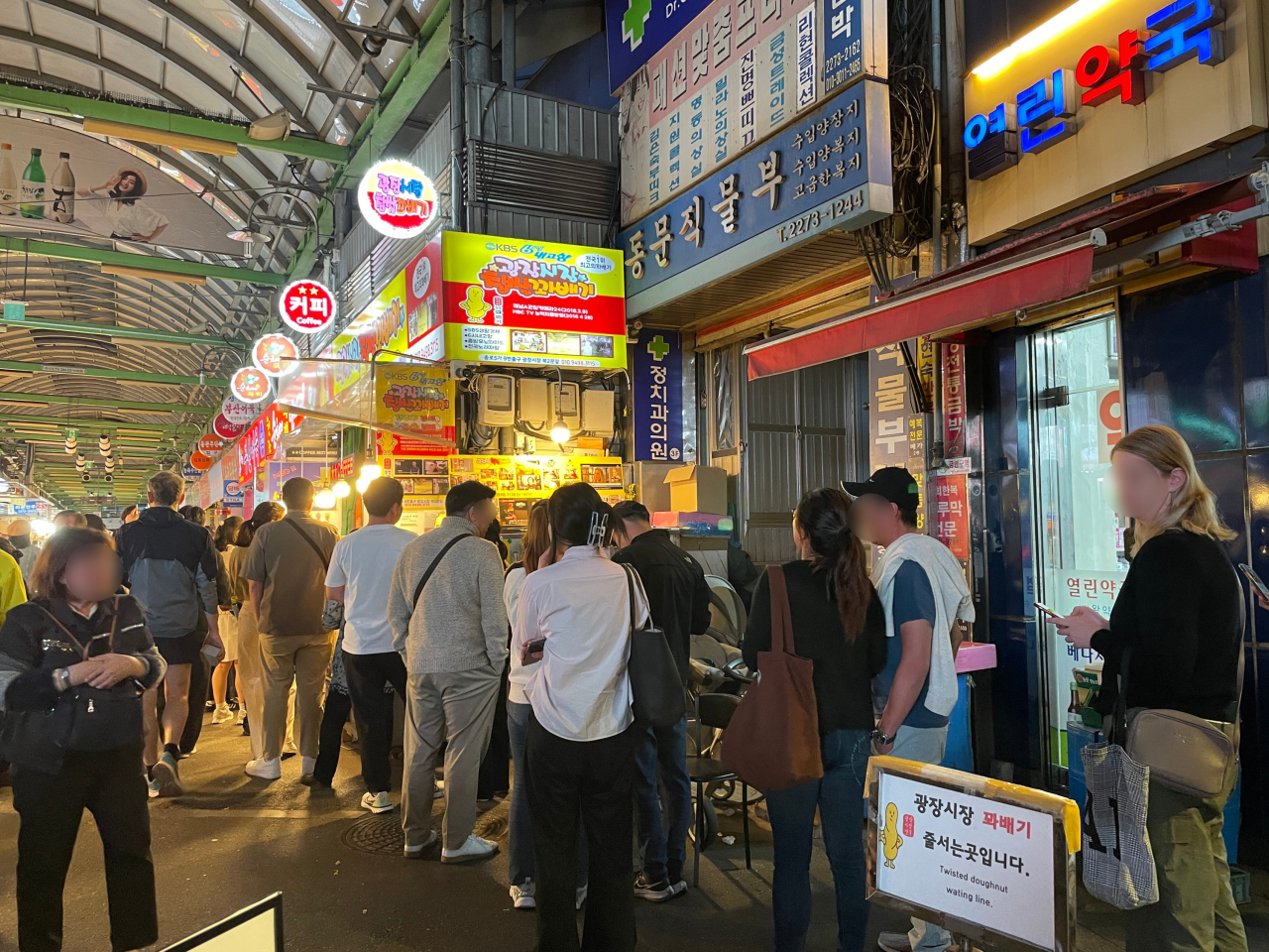 18일 오후 서울 종로구 광장시장 입구에 위치한 한 꽈배기가게 앞에 외국인 관광객이 줄을 서 있다. 전새날 기자