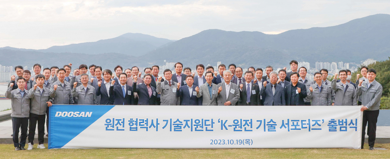 정연인(앞줄 오른쪽 세번째) 두산에너빌리티 사장과 박봉규(앞줄 왼쪽 일곱번째) 원비두기술 대표 등 참석자들이 지난 19일 경남 창원 두산에너빌리티 본사에서 열린 ‘K-원전 기술 서포터즈’ 출범식에서 기념촬영을 하고 있다. [두산에너빌리티 제공]