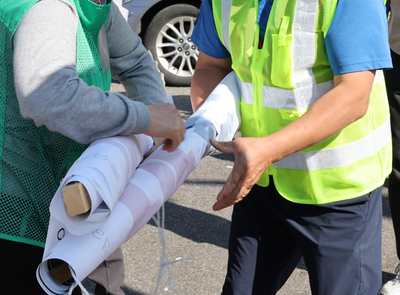 16일 오전 울산시 관계자가 울주군 범서읍의 한 전봇대에서 철거한 정당 현수막을 정리하고 있다. 연합뉴스