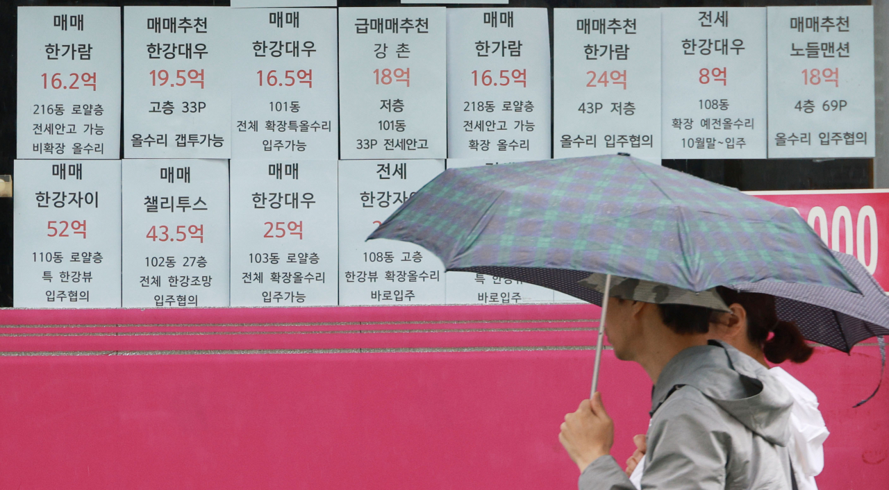서울 한 부동산중개사무소 앞을 시민이 지나가고 있다.[연합]