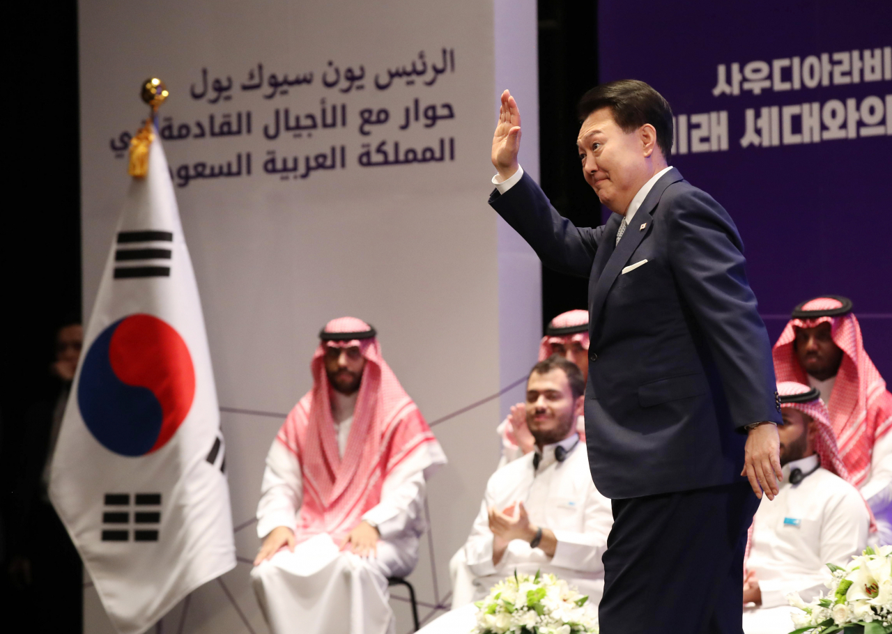 사우디아라비아를 국빈 방문 중인 윤석열 대통령이 23일(현지시간) 리야드의 킹 사우드 대학에서 열린 '사우디 미래 세대와의 대화'에서 강연을 위해 단상으로 향하며 손들어 인사하고 있다. [연합]