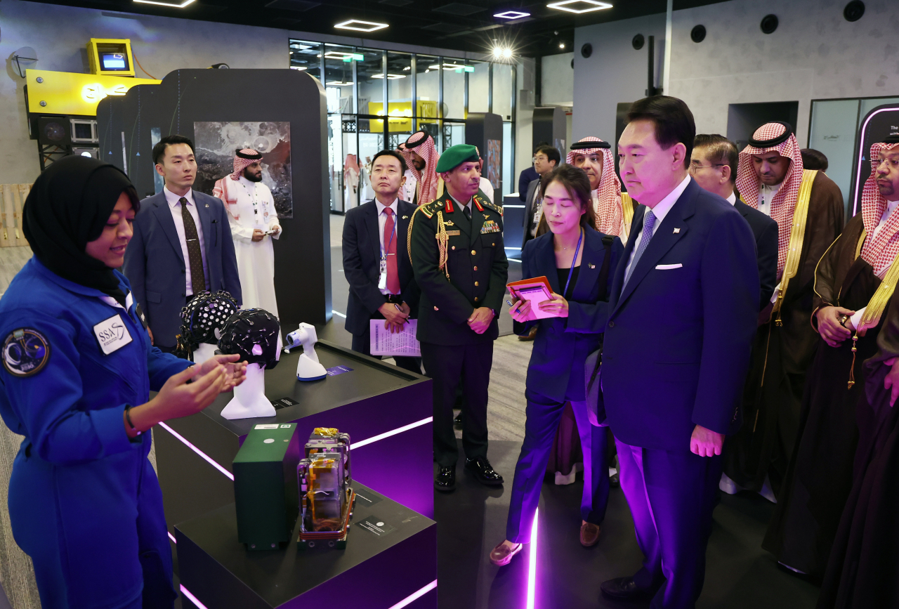 사우디아라비아를 국빈 방문 중인 윤석열 대통령이 23일(현지시간) 리야드의 왕립과학기술원에서 열린 한·사우디 미래기술 파트너십 포럼에 앞서 사우디 첫 여성 우주인 레이야나 바르나위에게서 사우디 우주국의 미래기술과 장비에 관한 설명을 듣고 있다. [연합]