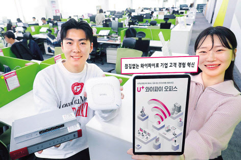 LG유플러스 임직원이 U+와이파이오피스를 구성하는 기업전용인터넷(AP)과 AP컨트롤러, 전원공급장치를 소개하는 모습 [LG유플러스 제공]