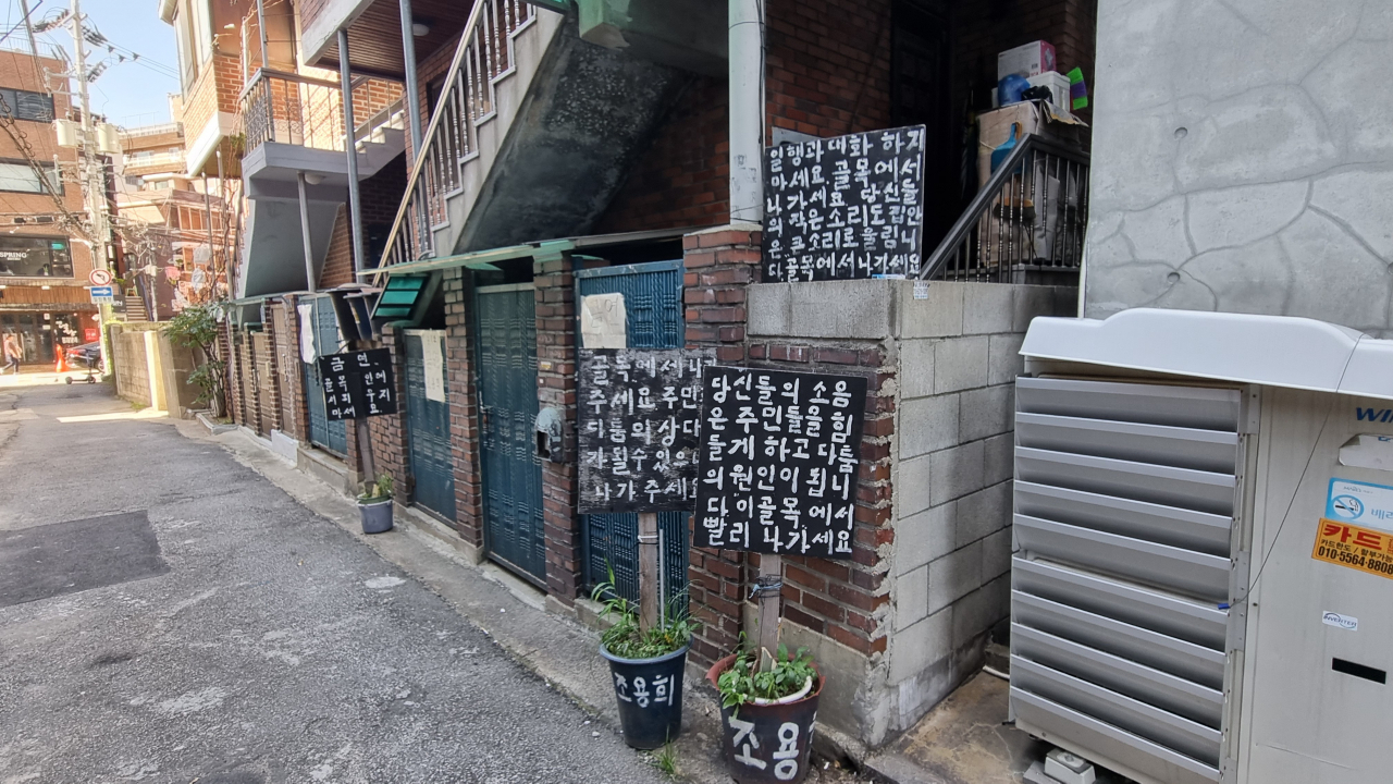 서울 합정동의 한 돈까스집 앞 주택에 붙어 있는 팻말. ‘골목에서 나가세요’라고 적혀 있다. 박지영 기자