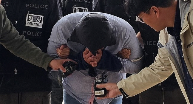70대 택시 기사를 살해하고 태국으로 도주한 혐의를 받는 40대 남성이 24일 오전 충남 아산경찰서로 압송되고 있다.[연합]