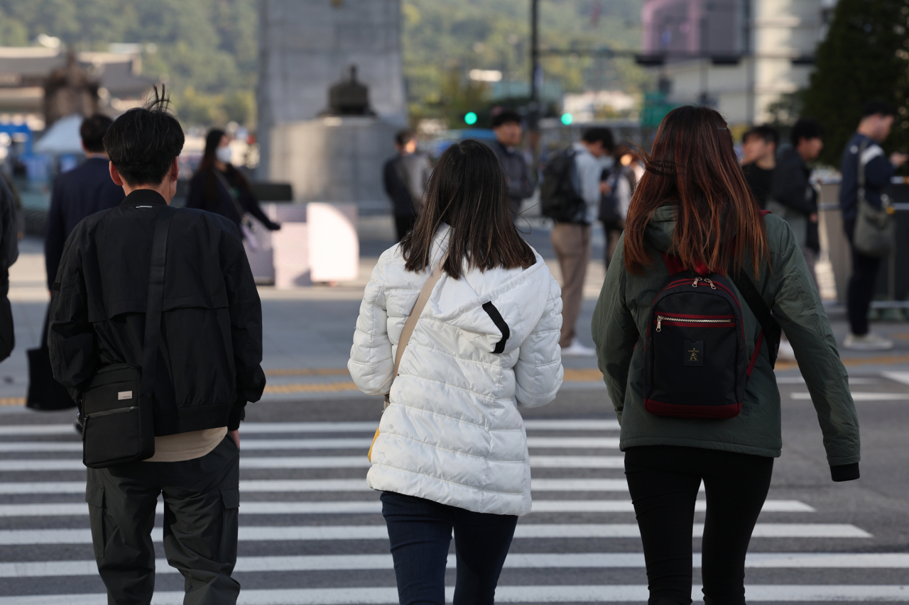 쌀쌀한 가을 날씨를 보인 5일 오전 서울 종로구 광화문네거리에서 외투와 긴팔옷을 입은 시민들이 발걸음을 재촉하고 있다. [연합]