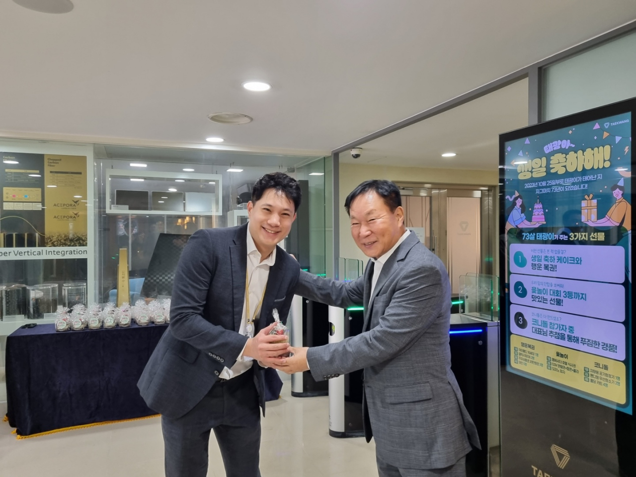 조진환(오른쪽) 태광산업 대표이사가 24일 서울 본사 정문에서 출근길 임직원들에게 기념 선물을 전달하고 있다. [태광산업 제공]