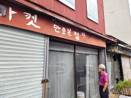 56년동안 목포 번화로에서 일한 김병진(77) 씨가 한때 자신이 일했던 수년간 비어있는 일본식 상가주택(적산가옥)을 바라보고 있다. 목포=김빛나 기자
