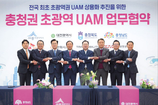 이종호(왼쪽부터) 티맵모빌리티 대표, 유영상 SK텔레콤 사장, 김태흠 충남도지사, 최민호 세종특별자치시장, 이장우 대전시장, 김영환 충북도지사, 어성철 한화시스템 대표이사, 김공덕 한국공항공사 청주공항장이 25일 세종시 지방자치회관에서 협약식을 마치고 기념촬영을 하고 있다. [티맵모빌리티 제공]