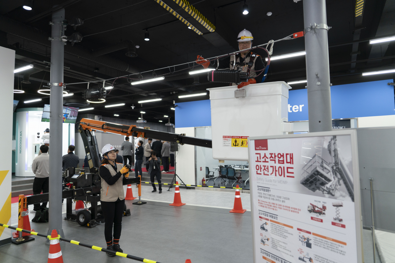 25일 대전 SK텔레콤 부사사옥에 위치한 안전체험교육관. 교육생이 안전 벨트 추락 체험에 참여하고 있다(위쪽). 인솔자가 고소작업대에 올라가 안전수칙을 준수하는 방법을 설명하고 있다.