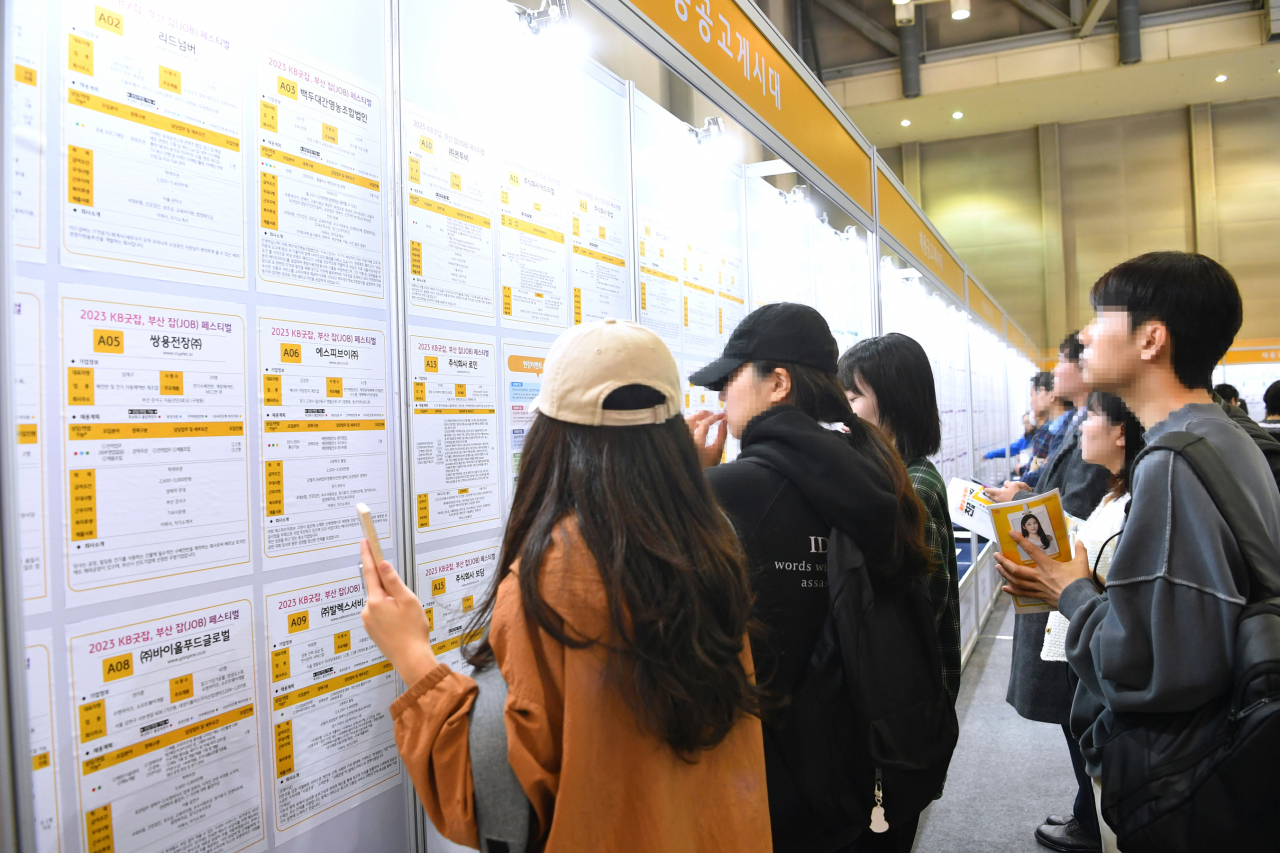 부산 해운대구 벡스코 제1전시장에서 부산시와 KB국민은행이 지난 18일 마련한 취업박람회인 ‘2023 KB굿잡, 부산 잡(JOB) 페스티벌’에서 구직자들이 채용정보를 살펴보고 있다. 사진은 기사 내용과 관련 없음 [연합]