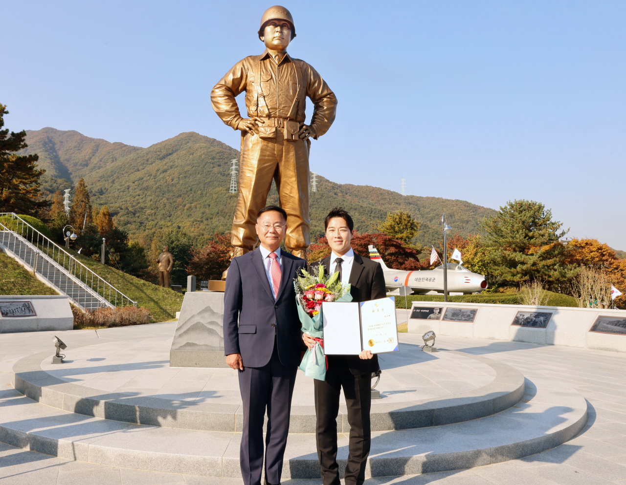 백선엽 장군 동상 앞에서 김재욱 칠곡군수(왼쪽)가 최영재 마스터에게 홍보대사 위촉장을 전달하고 있다.[칠곡군 제공]
