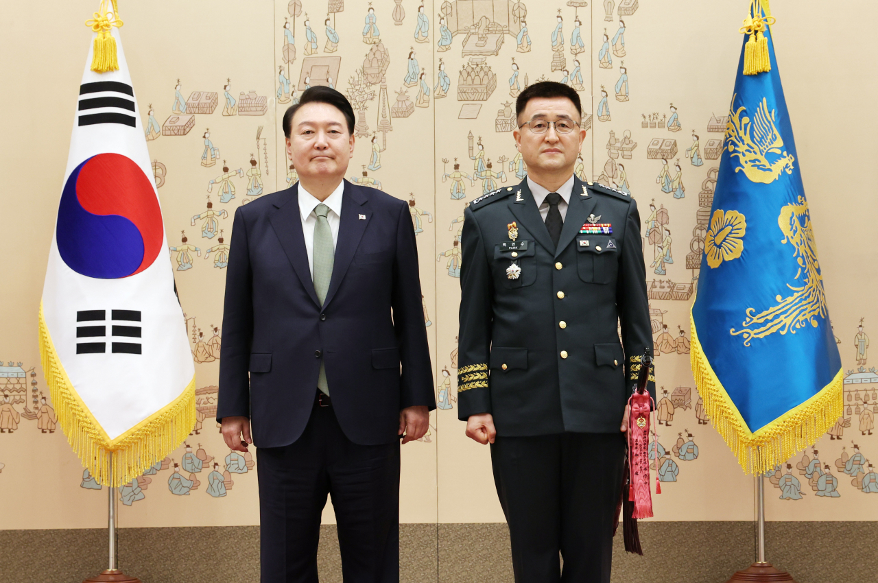 윤석열 대통령이 30일 서울 용산 대통령실 청사에서 열린 장성 진급·보직 신고 및 삼정검 수치 수여식에서 박안수 육군 참모총장에게 삼정검 수치를 수여한 뒤 기념촬영을 하고 있다. [연합]