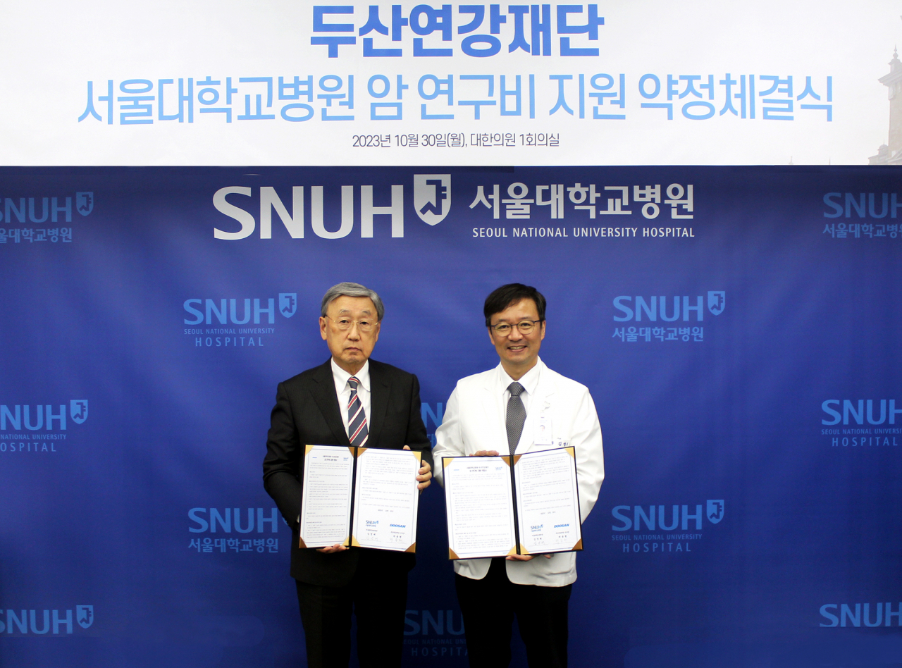30일 서울대병원에서 박용현(왼쪽) 두산연강재단 이사장과 김영태 서울대병원 병원장이 체결식 이후 기념촬영을 하고있다. [두산 제공]