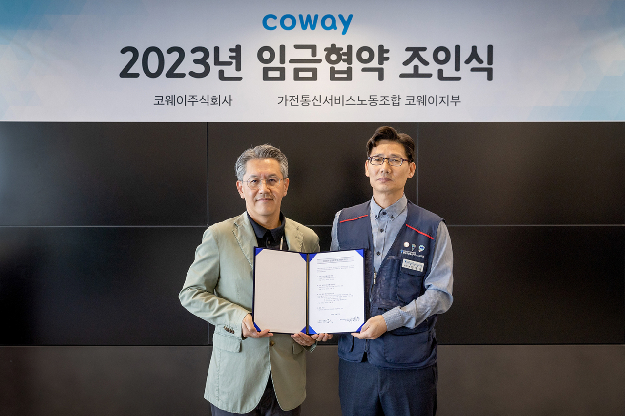 서장원 코웨이 대표이사(왼쪽)와 임창경 코웨이지부 지부장이 지난 30일 서울 구로구 코웨이 본사에서 열린 ‘2023년 임금협약 조인식’에서 기념촬영을 하고 있다. [코웨이 제공]