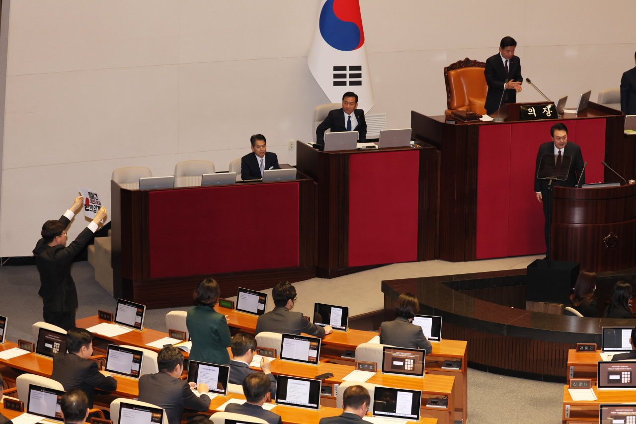 진보당 강성희 의원이 31일 국회 본회의장에서 시정연설을 위해 입장하는 윤석열 대통령을 향해 피켓을 들어보이고 있다. 연합뉴스