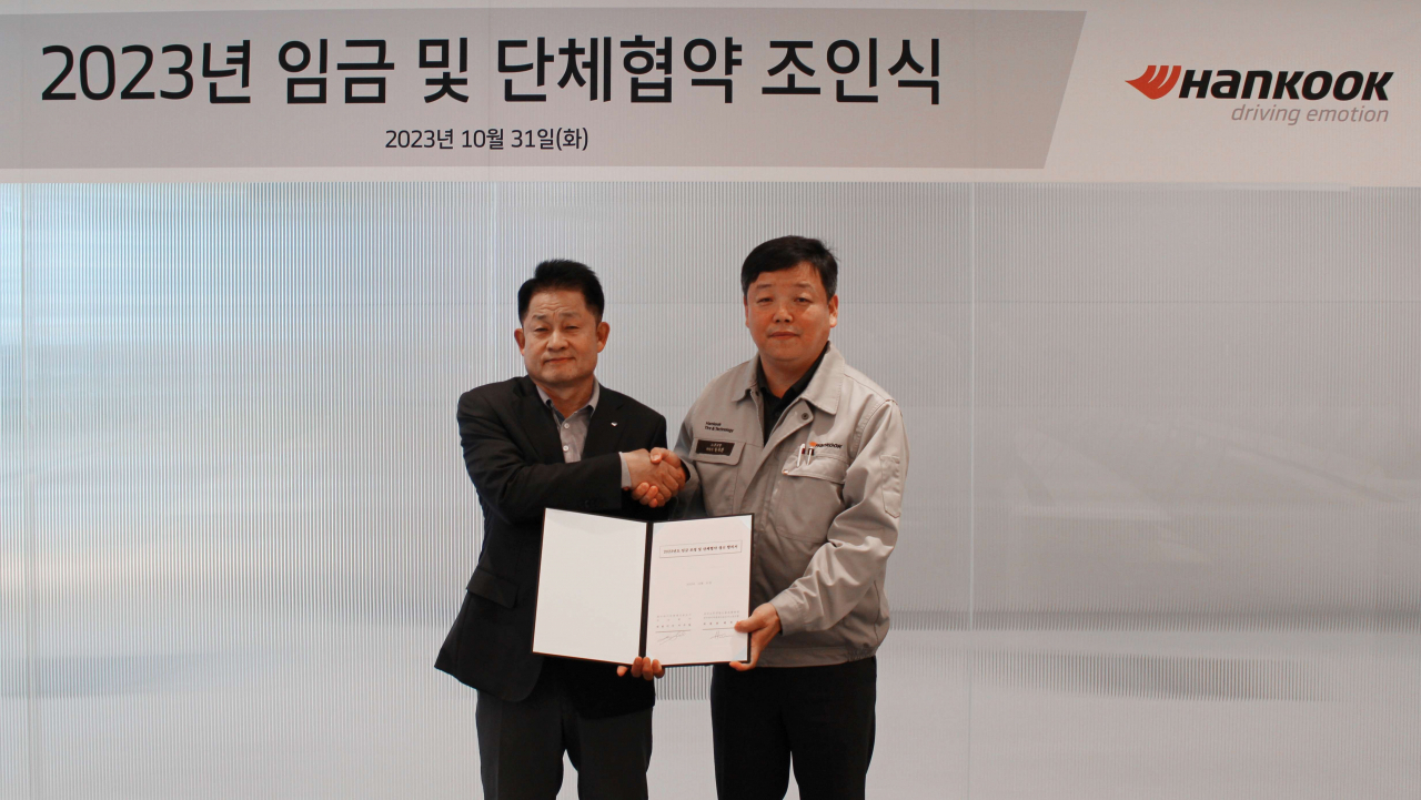 이수일(왼쪽) 한국타이어 대표이사와 현복환 한국노총 한국타이어앤테크놀로지노동조합 위원장이 2023년 임금 및 단체협약 조인식 후 기념사진을 촬영하고 있다. [한국타이어앤테크놀로지 제공]