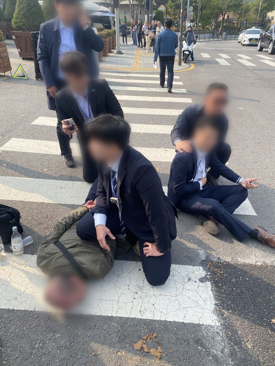 31일 오후 서울 용산구 대통령실 외곽에서 근무 중이던 경찰관 2명이 박 모 씨가 휘두른 흉기에 찔리는 일이 발생했다. 경찰이 흉기를 휘두른 박 씨(왼쪽)를 체포하고 있다. 오른쪽은 부상한 경찰관. [연합]