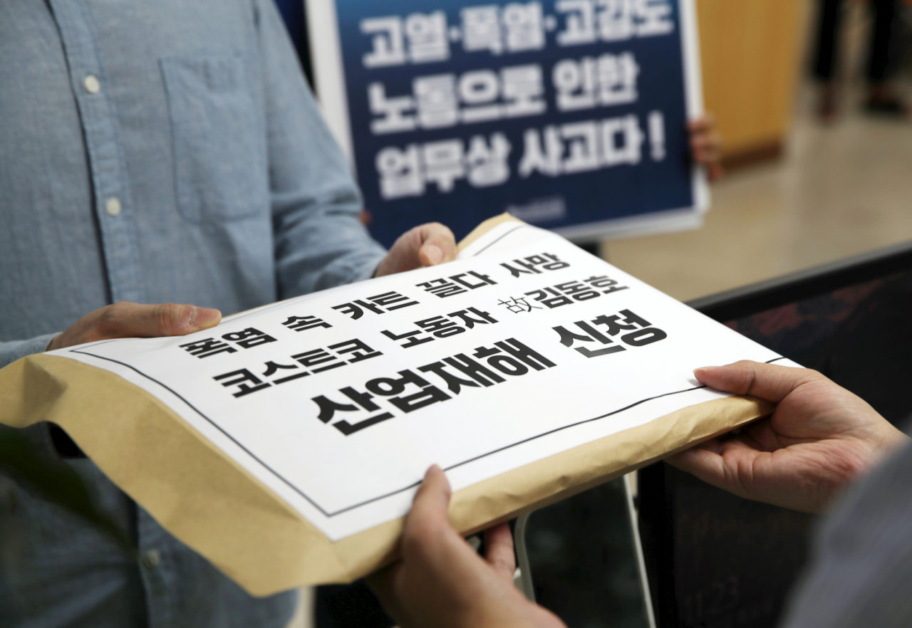 민주노총 서비스연맹 마트산업노동조합 회원들과 고 김동호 씨의 유족이 지난 8월 22일 경기 근로복지공단 성남지사에서 폭염 속 카트를 정리하다 사망한 고 김동호 씨의 산업재해 신청서를 제출하고 있다. 고 김동호 씨는 지난 6월 코스트코 하남점 주차장에서 카트 정리 업무를 하다 온열, 탈수로 인한 폐색전증으로 숨을 거뒀다. [뉴시스]