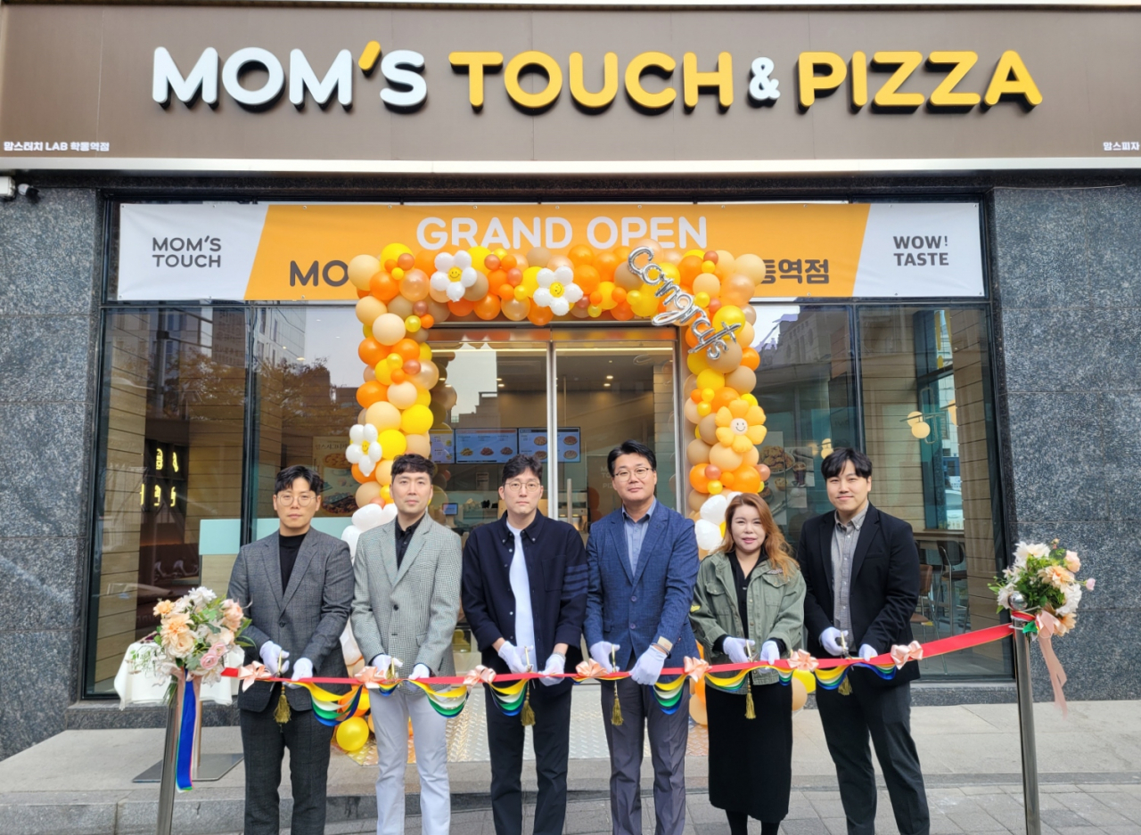 10월 31일 오전 서울 강남구 학동에 위치한 ‘상생형 안테나숍’에서 맘스터치 관계자와 가맹점주가 기념촬영을 하고 있다. [맘스터치앤컴퍼니 제공]