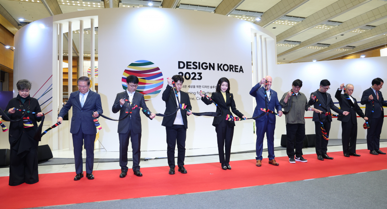 김건희 여사가 1일 서울 강남구 코엑스에서 열린 디자인코리아 2023 개막식에서 주요 참석자들과 함께 축하 세리머니로 묶인 스카프의 매듭을 풀고 있다. [연합]