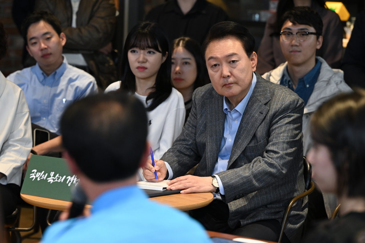 윤석열 대통령이 1일 서울 마포구 한 카페에서 열린 제21차 비상경제민생회의에서 택시운전기사 김호덕씨의 발언을 경청하고 있다 [연합]