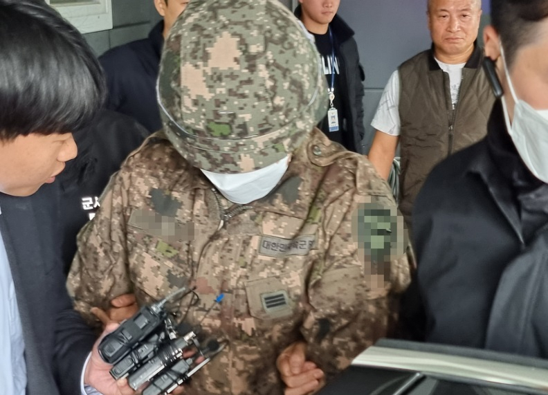 27일 오전 8시 45분께 경기 파주시 조리읍에 있는 한 도로에서 장갑차를 타고 있다 갑자기 뛰어 내려 시민들에게 흉기를 휘두른 현역 군인 A 상병이 군사 경찰로 인계되고 있다. [연합]